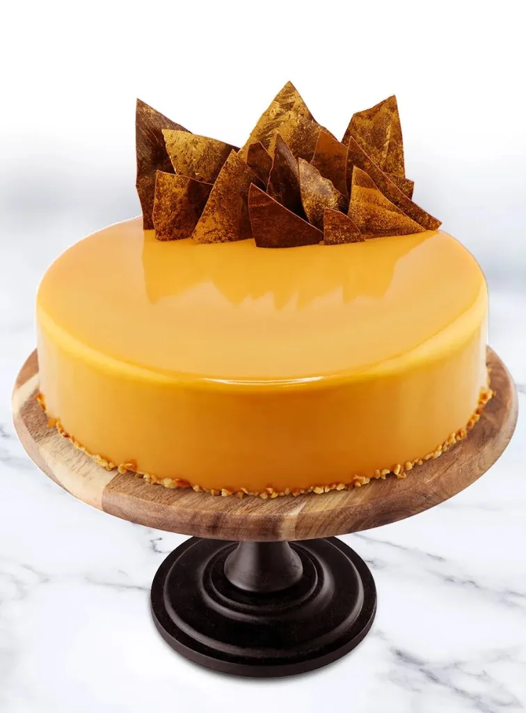Entremet mit oranger Spiegelglasur und goldenen Schokoladensegeln